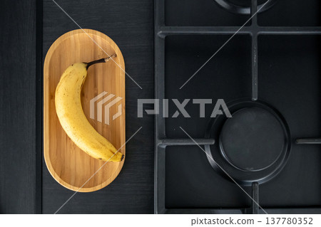 Ripe yellow banana in the kitchen near the sink. Ripe yellow banana in the kitchen near the sink. 137780352