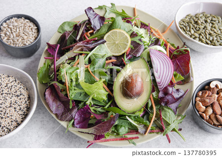Salad of avocado and vegetables mixed greens lettuce leaves ready to eat. 137780395