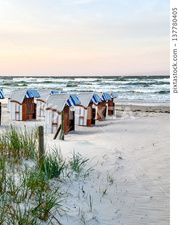 Sandy beach by the sea with dressing rooms. Sandy beach by the sea with dressing rooms. 137780405