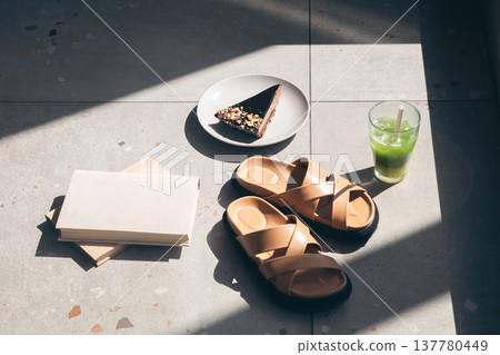 Slippers, lemonade, piece of cake and books on tiles by the pool. Slippers, lemonade, piece of cake and books on tiles by the pool. 137780449