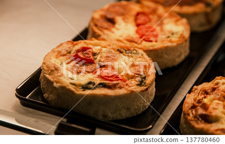 Small puff pies with vegetables and meat, quiches in a cafe window. 137780460
