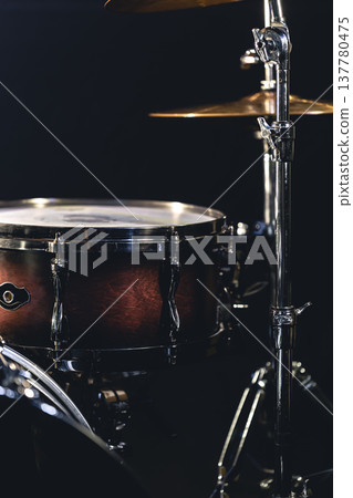 Snare drum on a blurred dark background, part of a drum kit. Snare drum on a blurred dark background, part of a drum kit. 137780475
