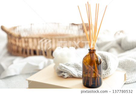 Spa composition with incense sticks and knitted element on a blurred background. Spa composition with incense sticks and knitted element on a blurred background. 137780532