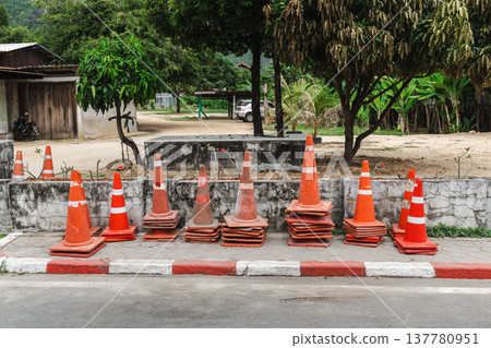 Stack of orange traffic cones on roadside near village street on Koh Samui Thailand Stack of orange traffic cones on roadside near village street on Koh Samui Thailand 137780951
