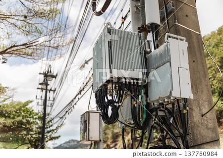 Telecommunication network equipment and antennas installed on concrete utility pole in tropical Thailand 137780984
