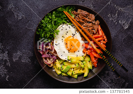 Traditional Korean dish Bibimbap: rice with vegetables beef and egg. Traditional Korean dish Bibimbap: rice with vegetables beef and egg. 137781545