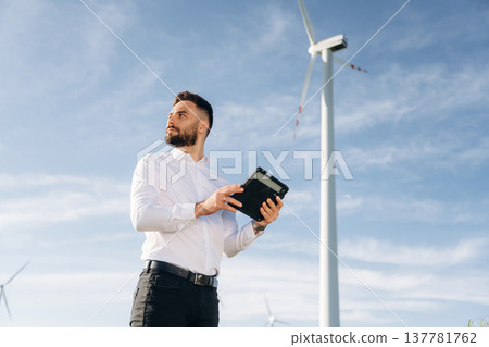 Digital tablet in hands. Engineer in field checking on wind turbine production 137781762