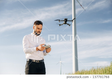 Controlling the drone. Engineer in field checking on wind turbine production 137781768