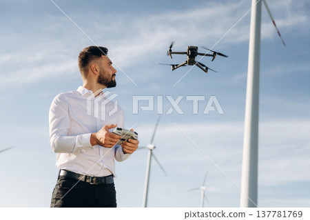 Controlling the drone. Engineer in field checking on wind turbine production 137781769