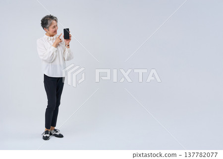 Senior woman operating a smartphone Senior woman operating a smartphone 137782077