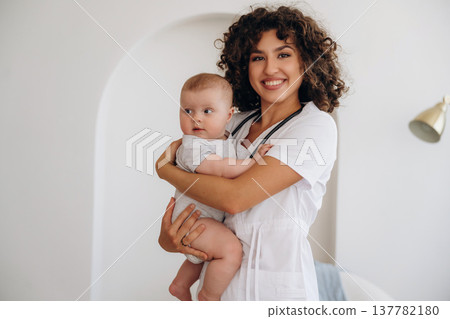 Professional medical worker. Female doctor is with newborn baby indoors Professional medical worker. Female doctor is with newborn baby indoors 137782180