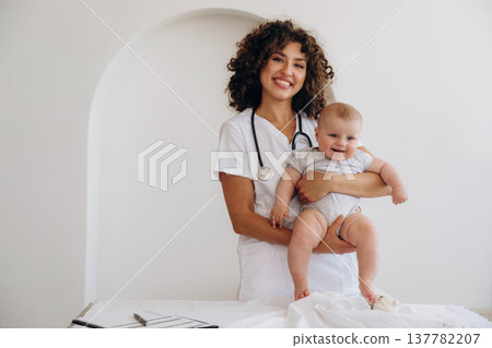 Female doctor is with newborn baby indoors Female doctor is with newborn baby indoors 137782207