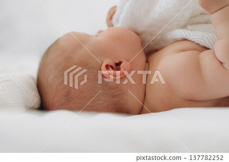 Cute newborn baby girl is lying down on the bed 137782252