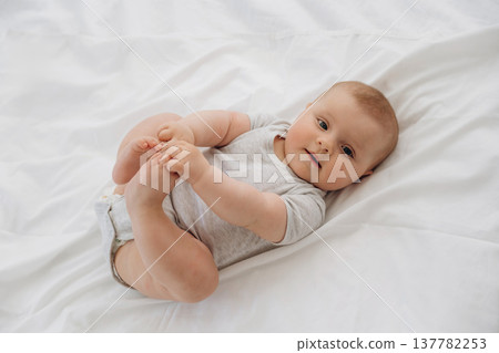 Cute newborn baby girl is lying down on the bed 137782253