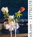 Handmade Fabric Flower Arrangement in White Ceramic Mug. Creative Upcycled Textile Floral Decor with White and Red Cloth Roses and Pink Ribbons. Unique DIY Home Craft Display on Dark Surface. 137782378