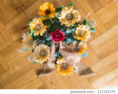 Handheld Rustic Sunflower and Red Rose Bouquet with Long Burlap Ribbon. Elegant Vertical Floral Arrangement for Anniversary, Wedding, or Romantic Gift. Beautiful Bright Yellow and Crimson Flowers. Handheld Rustic Sunflower and Red Rose Bouquet with Long Burlap Ribbon. Elegant Vertical Floral Arrangement for Anniversary, Wedding, or Romantic Gift. Beautiful Bright Yellow and Crimson Flowers. 137782379