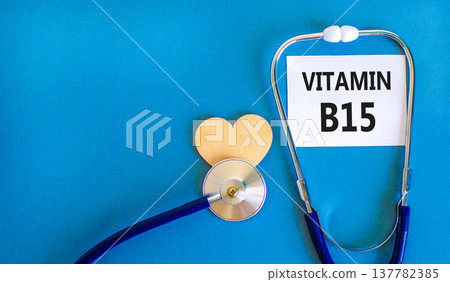 Vitamin B15 pantothenic acid symbol. Concept words Vitamin B15 on beautiful white card. Wooden heart and stethoscope. Beautiful blue background. Medical healthy lifestyle Vitamin B15 concept. 137782385