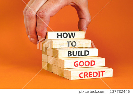 How to build good credit symbol. Concept words How to build good credit on beautiful wooden blocks. Beautiful orange background. Businessman hand. Business how to build good credit concept. Copy space How to build good credit symbol. Concept words How to build good credit on beautiful wooden blocks. Beautiful orange background. Businessman hand. Business how to build good credit concept. Copy space 137782446