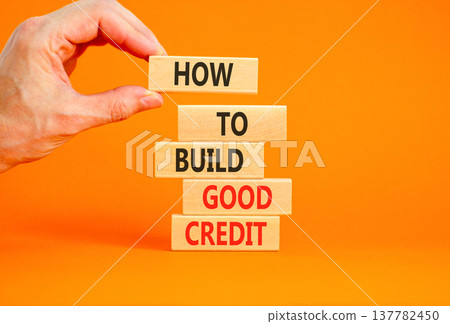 How to build good credit symbol. Concept words How to build good credit on beautiful wooden blocks. Beautiful orange background. Businessman hand. Business how to build good credit concept. Copy space How to build good credit symbol. Concept words How to build good credit on beautiful wooden blocks. Beautiful orange background. Businessman hand. Business how to build good credit concept. Copy space 137782450