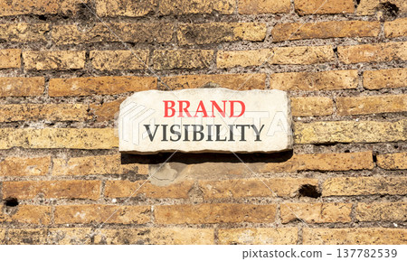 Brand visibility symbol. Concept words Brand visibility on beautiful big white sign plate. Beautiful old brown brick wall background. Business branding and brand visibility concept. Copy space. 137782539