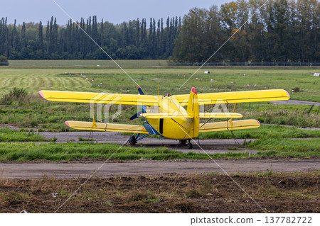 Yellow retro passenger biplane at the airfield Yellow retro passenger biplane at the airfield 137782722