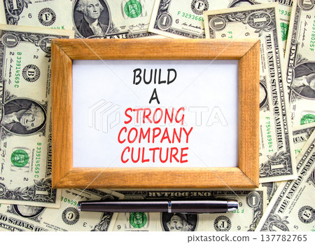 Strong company culture symbol. Concept words Build a strong company culture on beautiful wooden picture frame. Beautiful dollar bills background. Business strong company culture concept. Copy space. 137782765