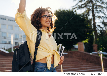 Hello hand gesture. Beautiful woman student is near the university outdoors Hello hand gesture. Beautiful woman student is near the university outdoors 137783693