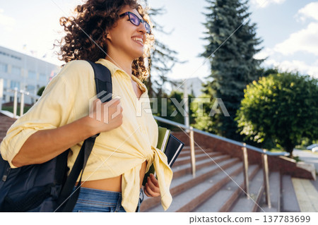 On the stairs. Beautiful woman student is near the university outdoors 137783699