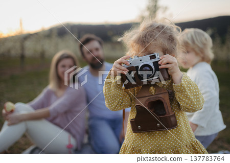 Family having picnic in spring nature, resting on picnic blanket. Family having picnic in spring nature, resting on picnic blanket. 137783764