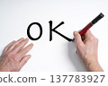 a hand writing the word OK with a marker  137783927