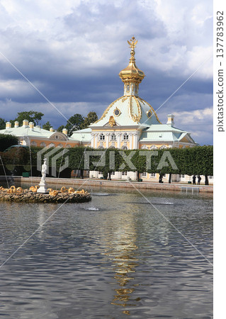 Russia, St. Petersburg, Peterhof, July 8, 2019. In the photo - the main court temple with a double-headed eagle on the dome in the Upper Park of the State Museum Reserve "Petergof" and people who walk Russia, St. Petersburg, Peterhof, July 8, 2019. In the photo - the main court temple with a double-headed eagle on the dome in the Upper Park of the State Museum Reserve "Petergof" and people who walk 137783962