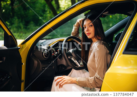 Side view, driver is sitting. Woman is with her car in the forest Side view, driver is sitting. Woman is with her car in the forest 137784047