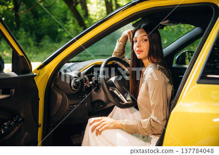 Side view, driver is sitting. Woman is with her car in the forest 137784048