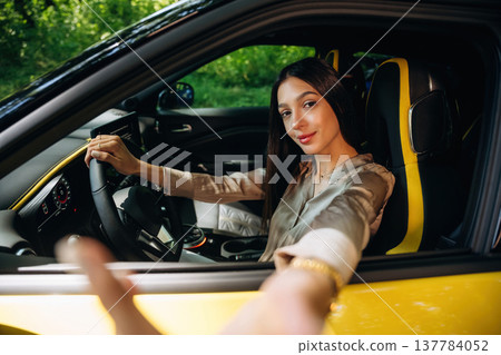 Making a selfie when sitting inside. Woman is with her car in the forest Making a selfie when sitting inside. Woman is with her car in the forest 137784052