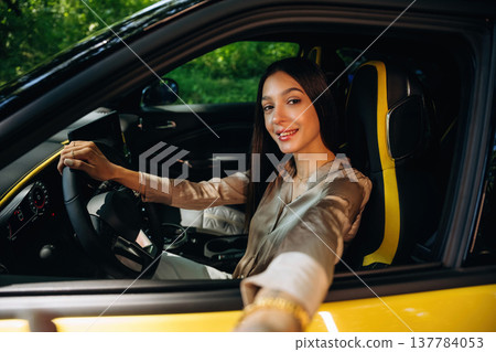 Making a selfie when sitting inside. Woman is with her car in the forest Making a selfie when sitting inside. Woman is with her car in the forest 137784053