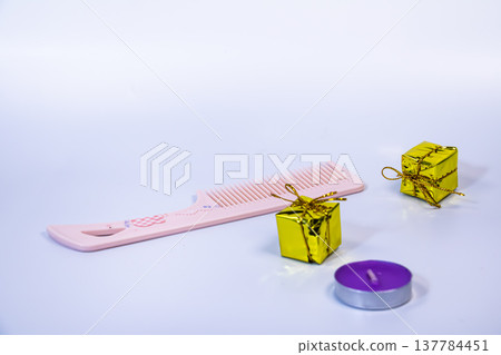 Pink hair comb with candle and small gift boxes arranged on white background. Minimal beauty and self care concept with grooming accessories and feminine lifestyle objects. Pink hair comb with candle and small gift boxes arranged on white background. Minimal beauty and self care concept with grooming accessories and feminine lifestyle objects. 137784451