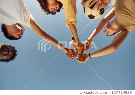 Upside down. View from below of people that are cheering with beer bottles Upside down. View from below of people that are cheering with beer bottles 137784929