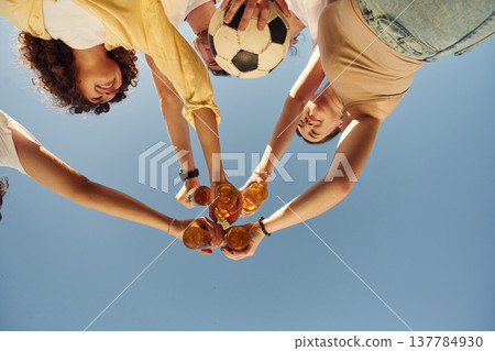 Upside down. View from below of people that are cheering with beer bottles Upside down. View from below of people that are cheering with beer bottles 137784930