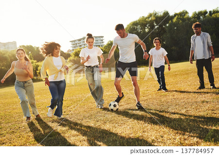 Hobby of sport. Group of friends are playing soccer on the field 137784957
