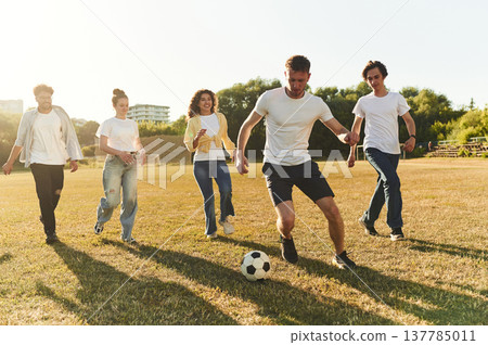 Competition and fun conception. Group of friends are playing soccer on the field Competition and fun conception. Group of friends are playing soccer on the field 137785011