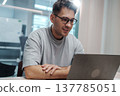 White Man Reviews Mockup Thoughtfully. Focused Caucasian Male Analyzes Design Layout On His Laptop 137785051