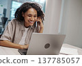Woman Chats Animatedly At Desk. Laughter And Conversation Spark Creativity At Shared Workspace Table 137785057