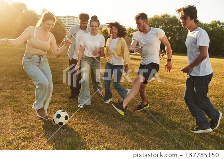 Competition and fun conception. Group of friends are playing soccer on the field Competition and fun conception. Group of friends are playing soccer on the field 137785150