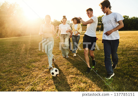 Competition and fun conception. Group of friends are playing soccer on the field Competition and fun conception. Group of friends are playing soccer on the field 137785151