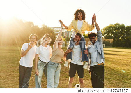 Positive facial expressions. Young friends are having fun on the field with soccer ball Positive facial expressions. Young friends are having fun on the field with soccer ball 137785157