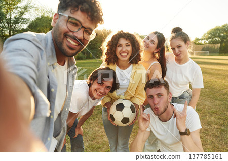 Selfie time, smiling. Young friends are having fun on the field with soccer ball Selfie time, smiling. Young friends are having fun on the field with soccer ball 137785161