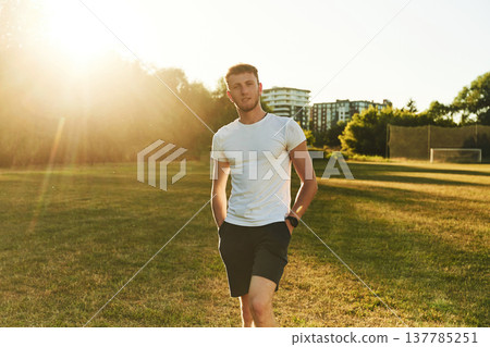 Front view of man in white shirt that is on the green field Front view of man in white shirt that is on the green field 137785251