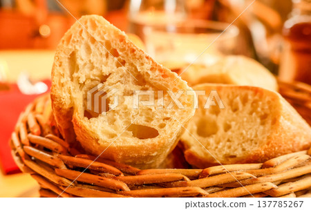 Slices of fresh french baguette bread in a basket, bringing a taste of Paris to the breakfast table 137785267