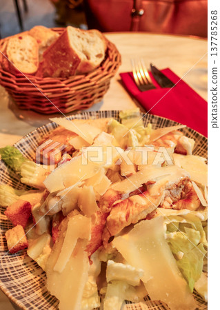 Caesar salad with grilled chicken and parmesan cheese served with French baguette in a restaurant in Paris, France 137785268