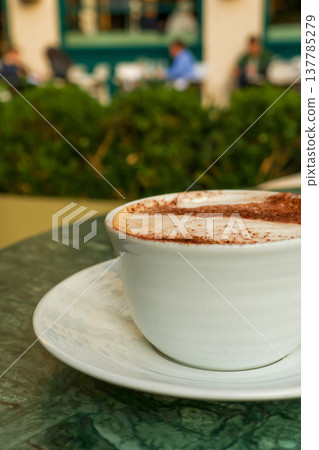 Cappuccino on a marble table at an outdoor cafe in Paris, France, enjoying morning travel and a relaxed lifestyle Cappuccino on a marble table at an outdoor cafe in Paris, France, enjoying morning travel and a relaxed lifestyle 137785279